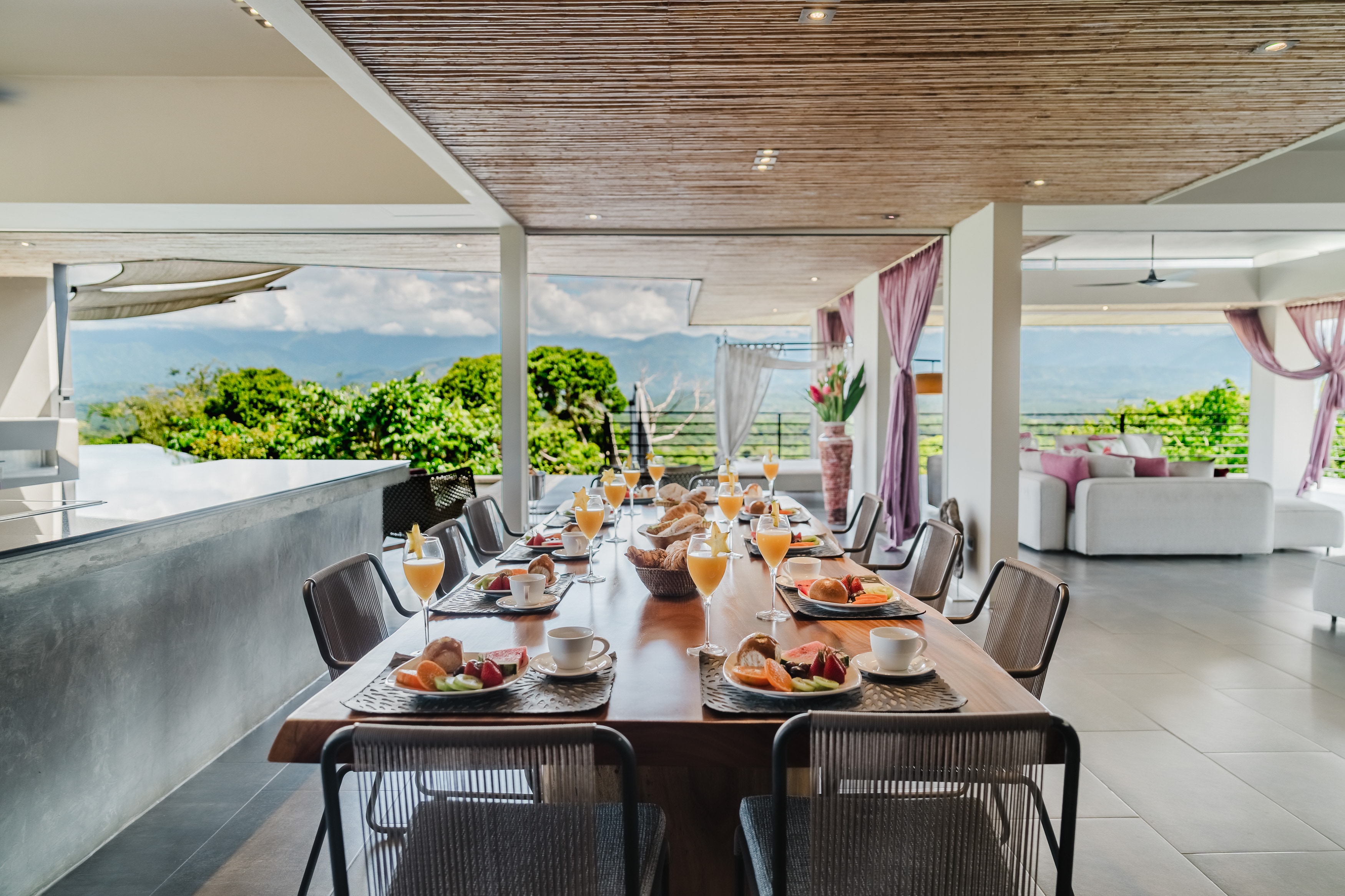 The dining table set for ten, the mountains beyond the terrace
